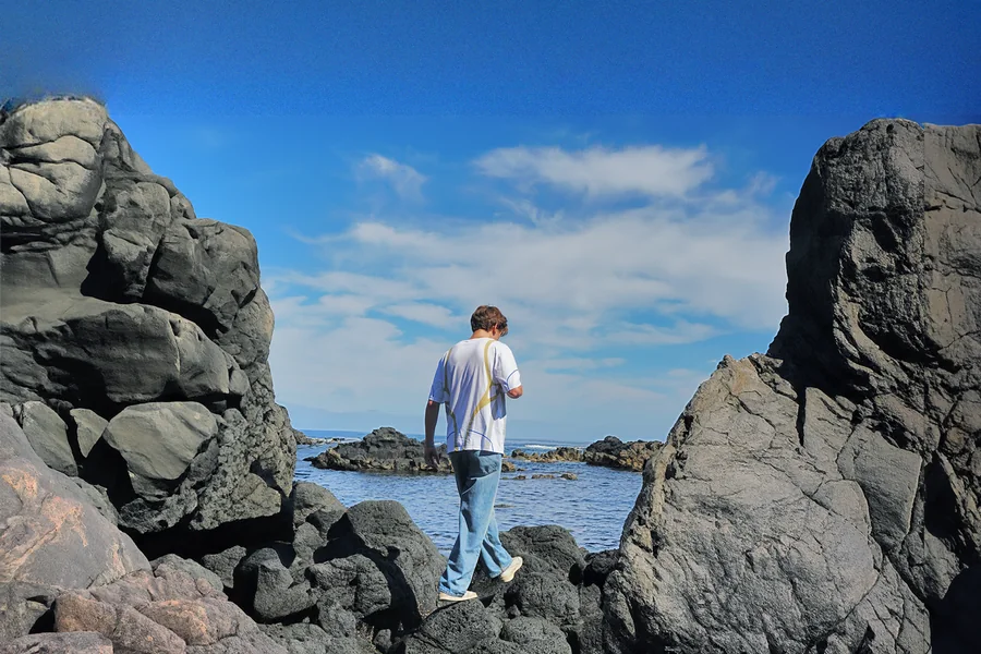 Walking the coastline rocks in the Drop 1 tee