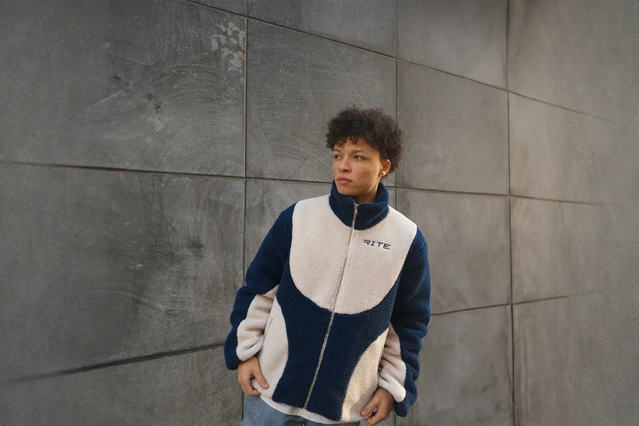 The Drop 2 sherpa fleece against a concrete wall
