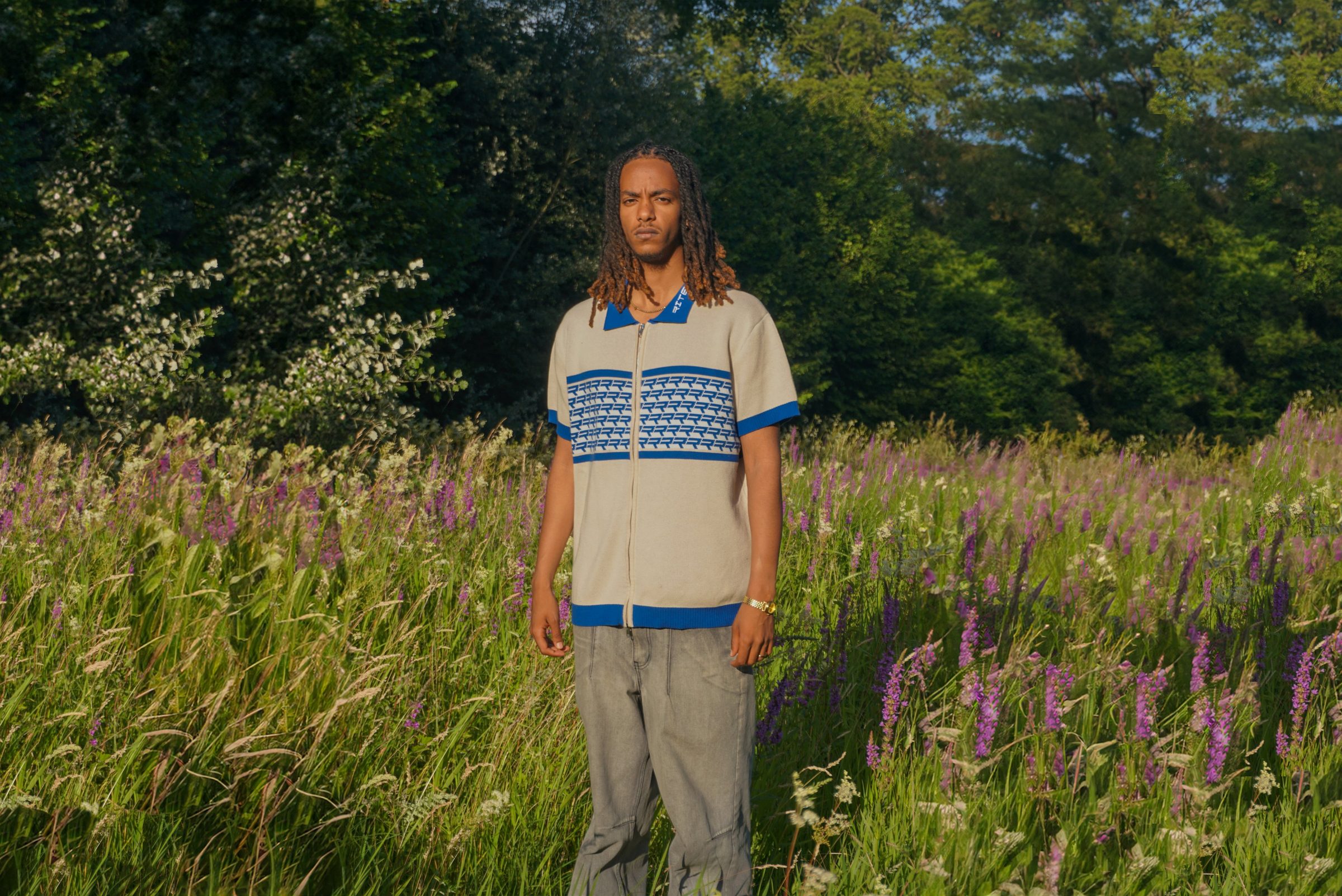 The RITE knit zip polo, worn in a field of wildflowers